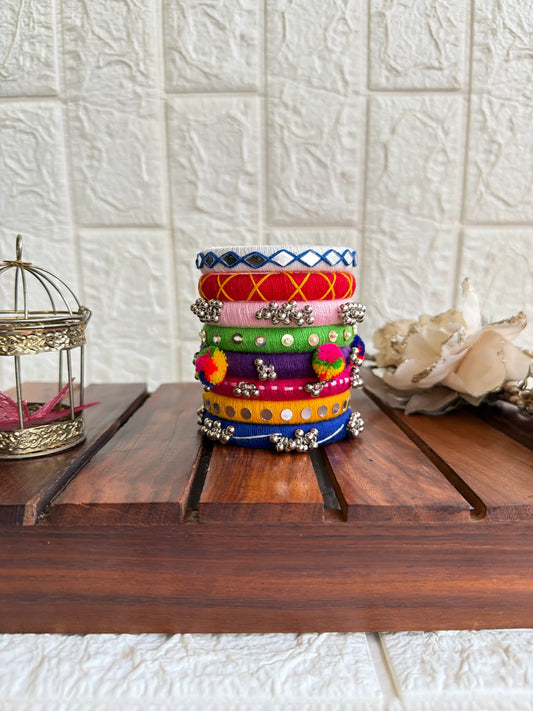 Aadhya Bangles — Multicolor thread bangles with mirror work, silver bells, kundan stones, silver charm ghungroo, parrot motifs, cowrie shells side view