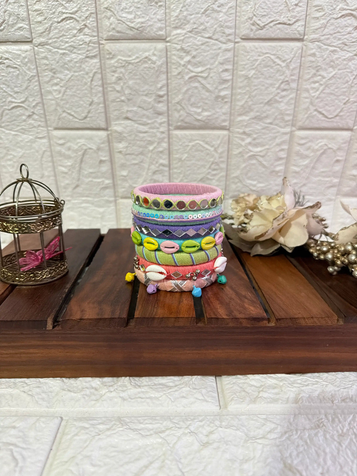 Aadhya Bangles — Multicolor thread bangles with mirror work, silver bells, kundan stones, silver charm ghungroo, parrot motifs, cowrie shells Side view