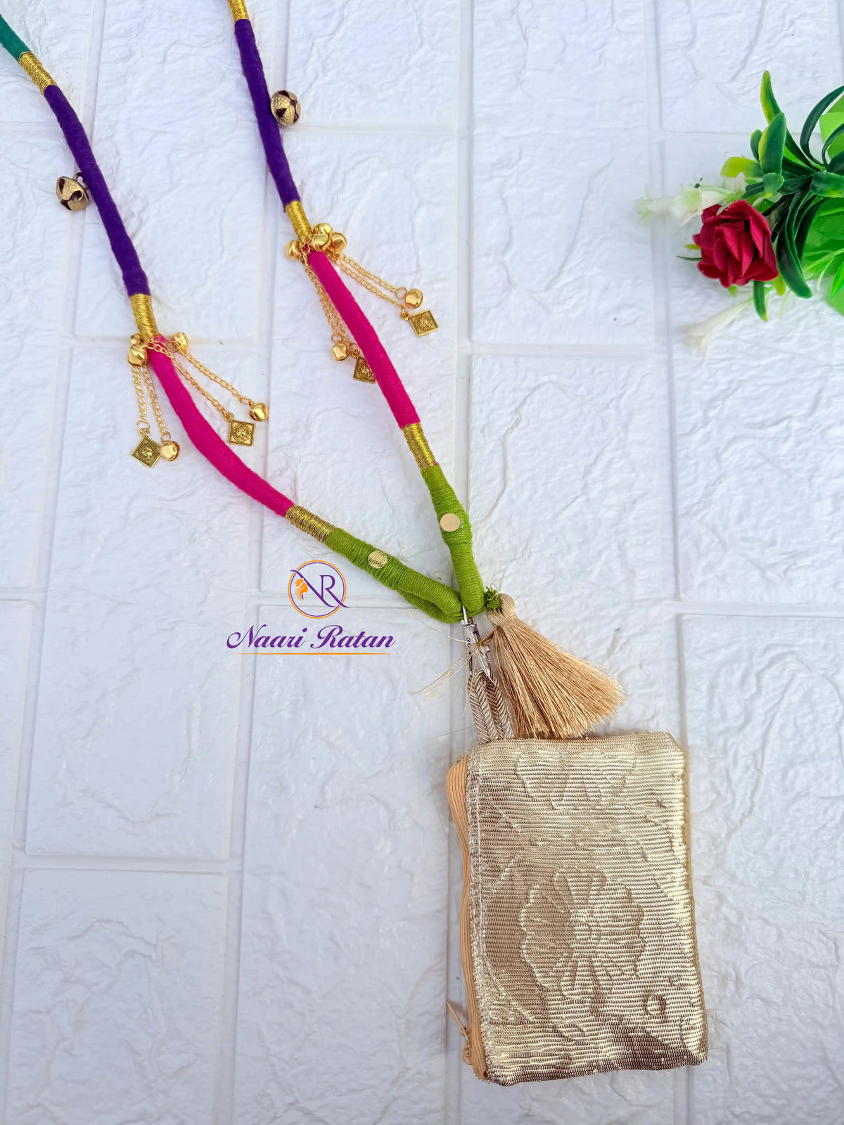 Purple and pink thread-wrapped mobile sling bag with golden charm tassels by Naari Ratan