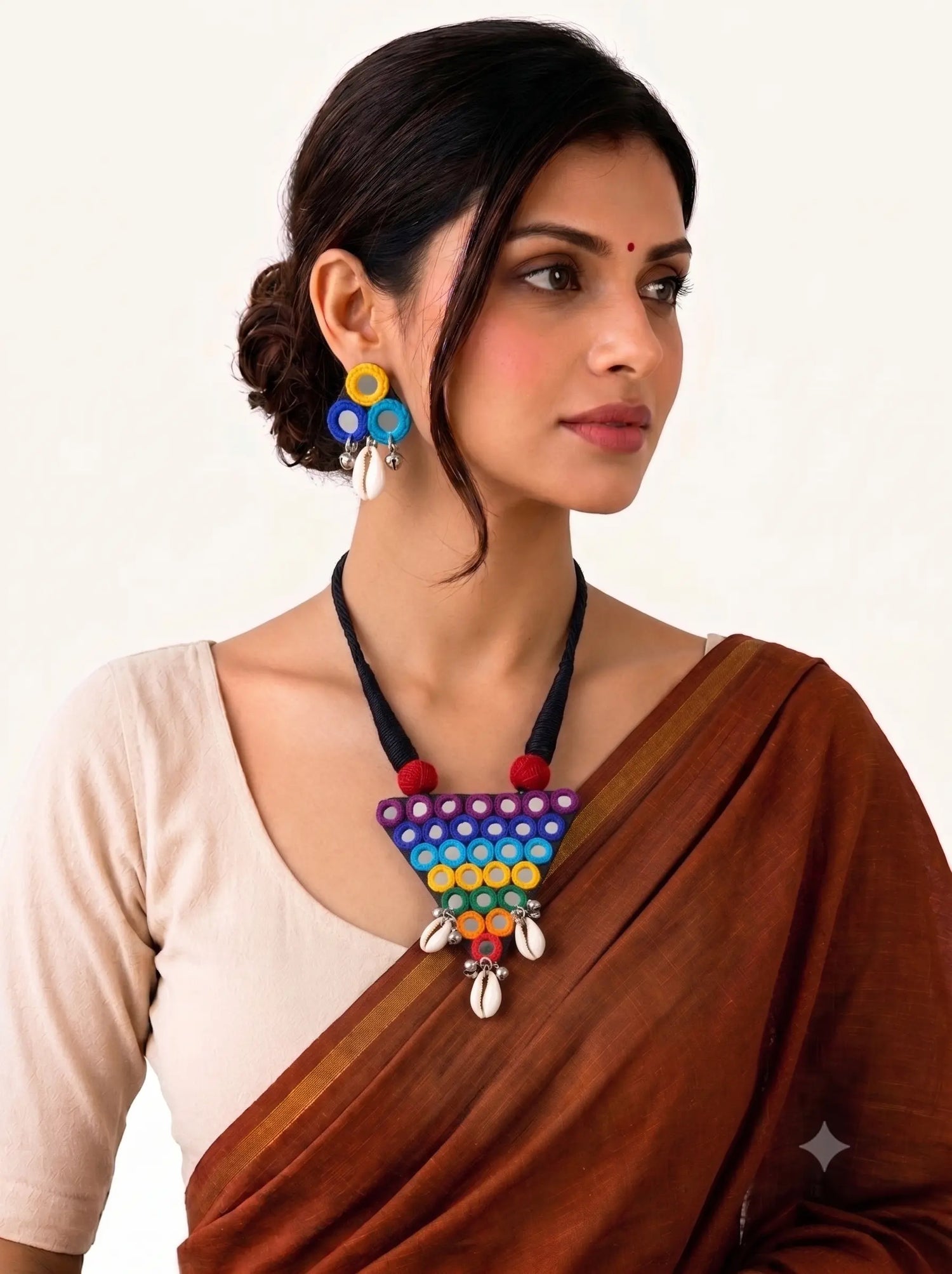 Woman wearing handmade multicolor Navratri necklace and earrings set with mirror work and cowrie shells by Naari Ratan