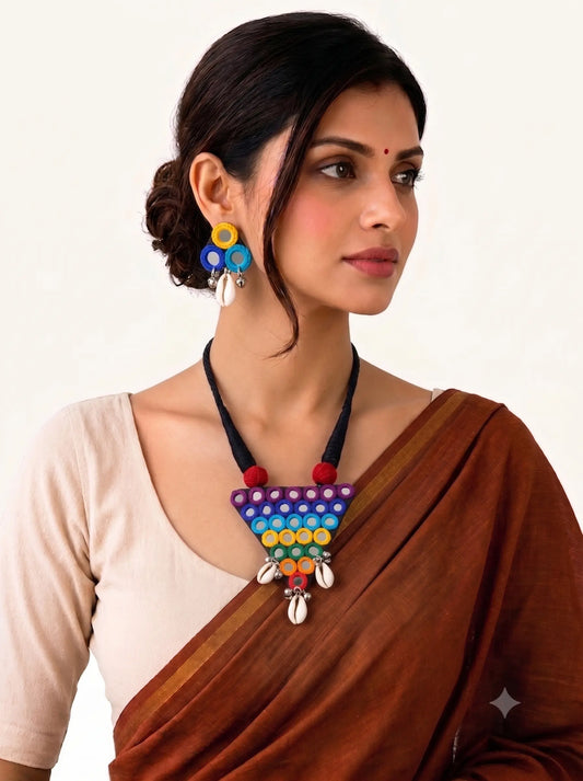 Woman wearing handmade multicolor Navratri necklace and earrings set with mirror work and cowrie shells by Naari Ratan